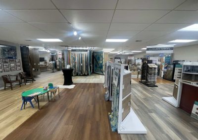 Showroom at Eastman's Carpets Inc. with wood flooring samples, display racks, and a small kids' table with chairs and toys—your destination for quality flooring solutions.