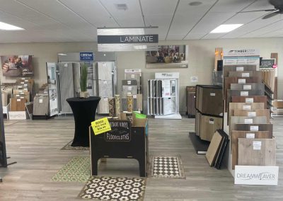 Eastman's Carpets flooring showroom displays various laminate, vinyl, and carpet samples with product signs and showcases, offering expert flooring services.