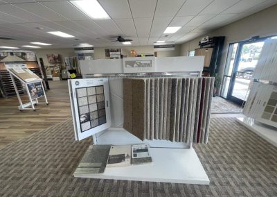 Carpet samples on display in a flooring showroom with brochures and flooring solutions from Eastman's Carpets visible.