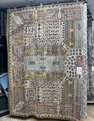 A large, ornate rug from Eastman's Carpets features intricate geometric and floral patterns in beige, gold, blue, and red tones—an elegant flooring choice for any space.